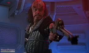 Kruge points a gun at the crew member that displeased him