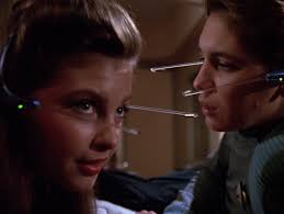 Robin and Wesley on the bed with their fake headsets