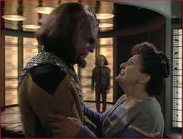 Worf and his mother embrace while Alexander is in the background.