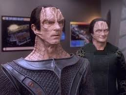 Gul Dukat looking shocked while Garak looks on in the background mighty pleased with himself.