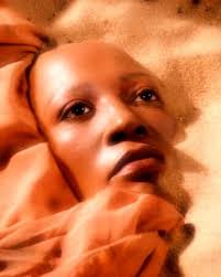 A black woman's face in the sand