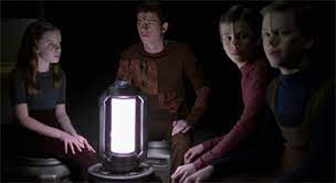 The Borg children around a light as Neelix tells the story