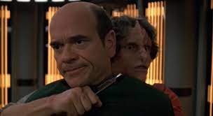 Iko holding a knife to a bemused EMH