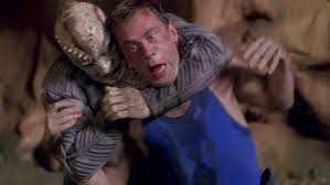 Tucker being put in a headlock by the alien he's trapped with